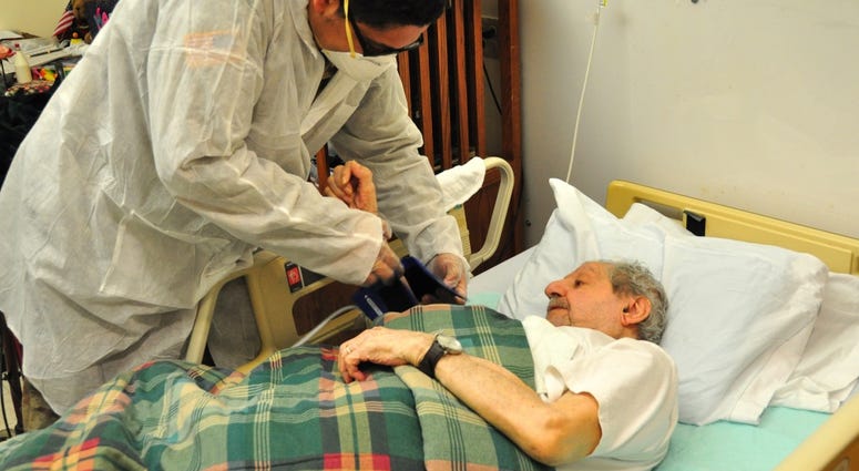 U.S. Army Spc. Jabari Ashanti, a Combat Medic with the 1st Battalion, 114th Infantry Regiment, New Jersey Army National Guard (NJARNG), checks a resident’s blood pressure at the New Jersey Veterans Memorial Home at Menlo Park in Edison, N.J., April 17, 20 U.S. Army Spc. Jabari Ashanti, a Combat Medic with the 1st Battalion, 114th Infantry Regiment, New Jersey Army National Guard (NJARNG), checks a resident’s blood pressure at the New Jersey Veterans Memorial Home at Menlo Park in Edison, N.J., April 17, 20