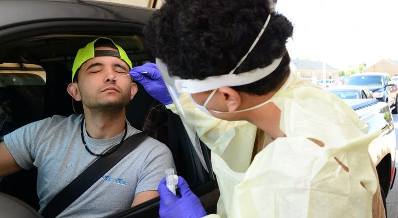 Captain James A. Lovell Federal Health Care Center Hospitalman Recruit Yavir Berrios-Santiago collects a nasal swab from a Naval Station Great Lakes Recruit Training Command employee during drive-through COVID-19 screening at Lovell FHCC in North Chicago. Captain James A. Lovell Federal Health Care Center Hospitalman Recruit Yavir Berrios-Santiago collects a nasal swab from a Naval Station Great Lakes Recruit Training Command employee during drive-through COVID-19 screening at Lovell FHCC in North Chicago.