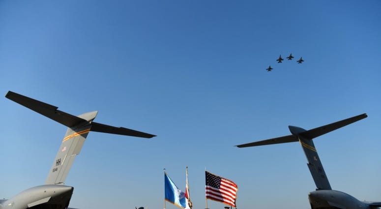 The United Nations Command Honor Guard prepares to transfer remains onto waiting C-17 Globemaster IIIs