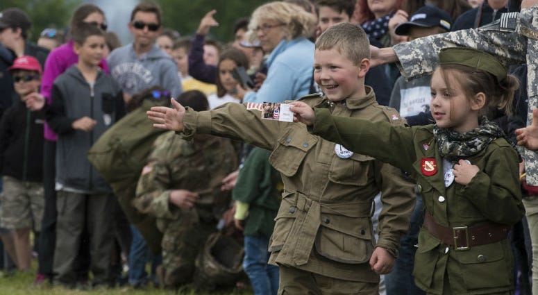 A French boy, dressed in a mock WWII-era uniform displaying the American flag, Canadian flag and an illustrated pin stating “I heart our veterans." Over 1,000 U.S. paratroopers participate in largest airborne operation since WWII to commemorate 75th anniversary of D-Day.