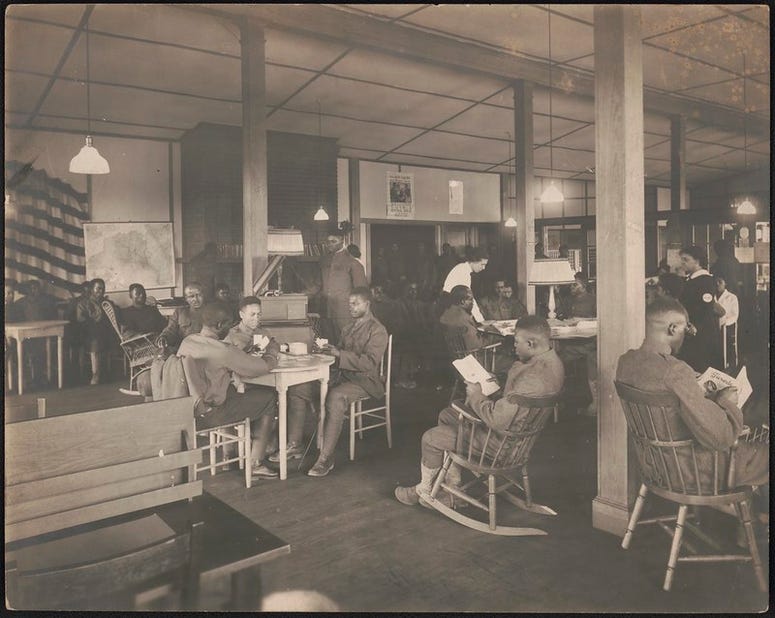 African American soldiers reading, playing cards, and relaxing in Y.W.C.A Hostess House, 1918 African American soldiers in Y.W.C.A Hostess House during World War I