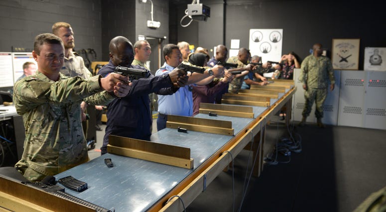 Training Security Assistance Field Activity Foreign Students try out the Gunner's Mate 'A' School's Fire Arms Training Simulator