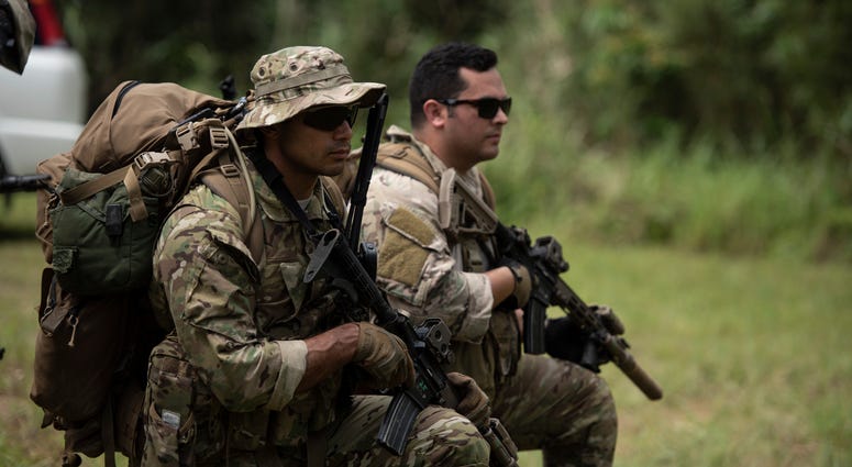 A U.S. Army Green Beret from 1st Battalion, 1st Special Forces Group (Airborne), and Air Force Staff Sgt. Mike Triana, independent duty medical technician paramedic from the 67th Fighter Squadron, establish a security perimeter during a small unit tactics Big changes to grueling Special Forces course draw scrutiny