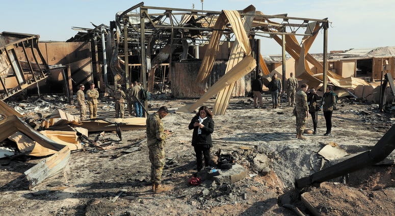 Media outlets visit one of the many impact sites created by the recent missile attacks at Al Asad Air Base, Iraq