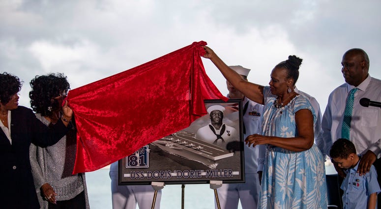Family of late Ship's Cook 3rd Class Doris Miller unveil a plaque commemorating the future Navy ship, Ford-class aircraft carrier USS Doris Miller (CVN 81)
