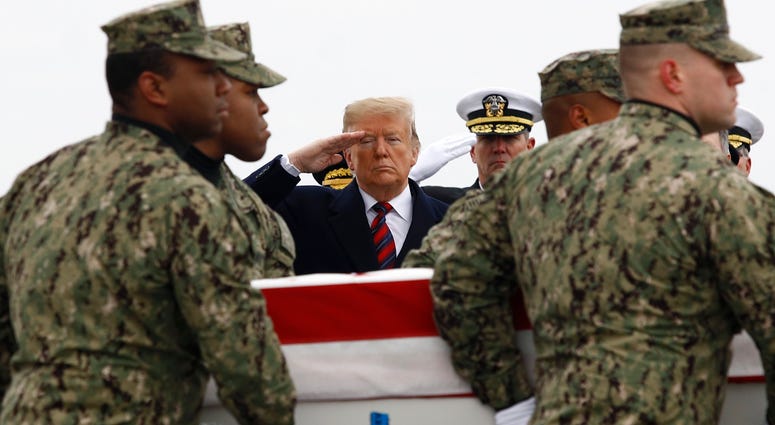 President Donald Trump salutes as a U.S. Navy carry team moves a transfer case containing the remains of Scott A. Wirtz, Saturday, Jan. 19, 2019, at Dover Air Force Base, Del. According to the Department of Defense, Wirtz, a civilian and former Navy SEAL