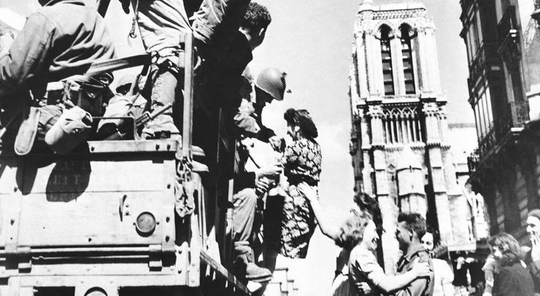 In this Aug. 28, 1944 file photo, French girls rush to greet American soldiers