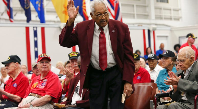 Tuskegee Airmen James L. Bynum, 98, waves as he is introduced during a ceremony at Joint Base San Antonio-Fort Sam Houston