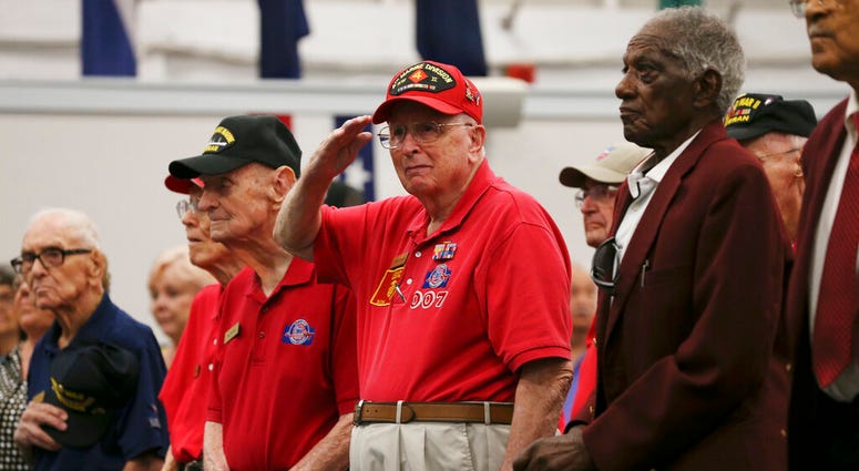 LeRoy Leonard, 93, salutes as the 323rd Army Band plays the U.S. military songs during a ceremony at Joint Base San Antonio-Fort Sam Houston