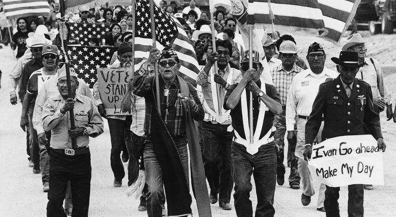 In this July 8, 1986, file photo, World War II Navajo veterans and supporters march through the reservation in a show of solidarity against giving up any of their land to the Hopis in Arizona.