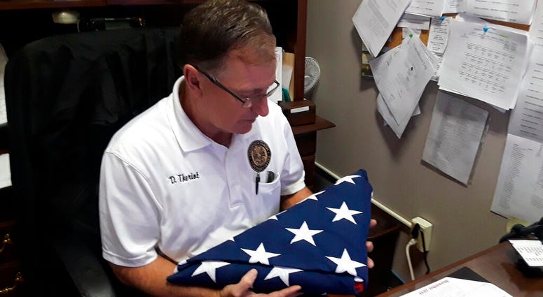 Danny Theriot, the Terrebonne Coroner's Office chief investigator, holds a flag
