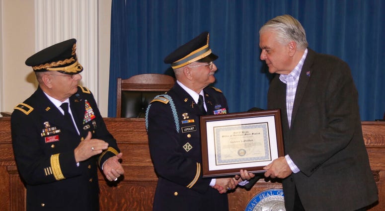 In this Dec. 11, 2019, photo, Army veteran Andrew LePeilbet, center, whose platoon came under heavy fire in Vietnam in 1969, receives a certificate from Gov. Steve Sisolak, right, for a Silver Star medal