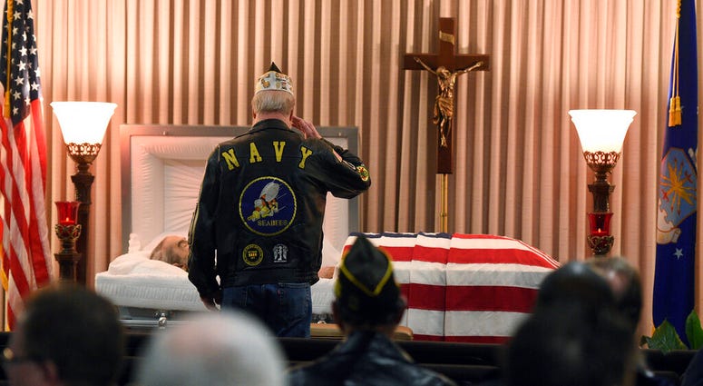 A mourner salutes.