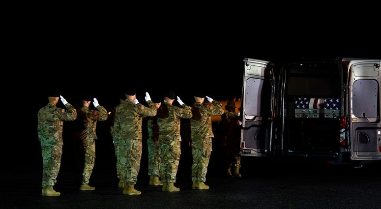 A U.S. Army carry team salutes as door attendant Staff Sgt. Tiliyah Tillman closes the vehicle doors after moving the transfer cases containing the remains of Sgt. 1st Class Javier Gutierrez, of San Antonio, Texas, and Sgt. 1st Class Antonio Rodriguez