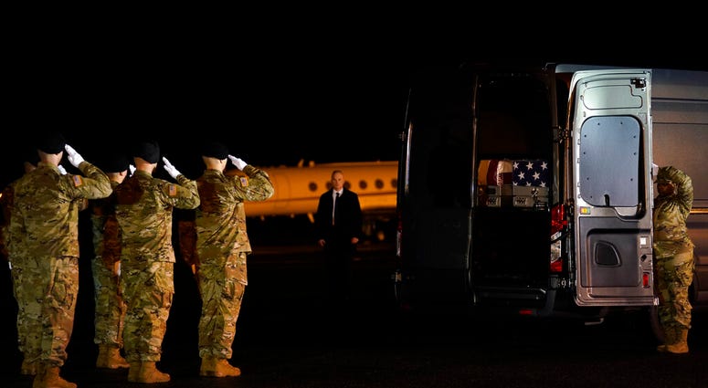 A U.S. Army carry team salutes after moving transfer case containing the remains of Sgt. 1st Class Javier Gutierrez, of San Antonio, Texas, and Sgt. 1st Class Antonio Rodriguez