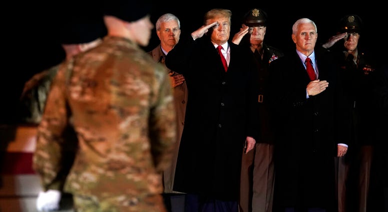 President Donald Trump and Vice President Mike Pence watch as a U.S. Army carry team moves a transfer case containing the remains of Sgt. 1st Class Javier Gutierrez