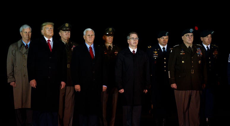 President Donald Trump and Vice President Mike Pence watches as a U.S. Army carry team salutes the transfer case's containing the remains of Sgt. 1st Class Javier Gutierrez, of San Antonio, Texasa and Sgt. 1st Class Antonio Rodriguez