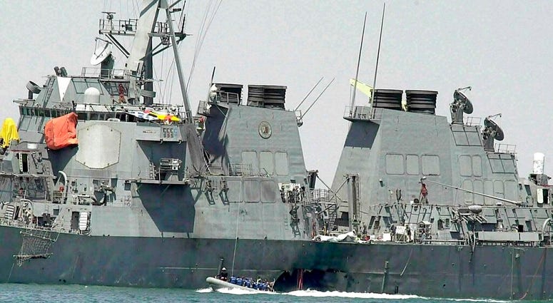 In this Oct. 15, 2000 file photo, experts in a speed boat examine the damaged hull of the USS Cole