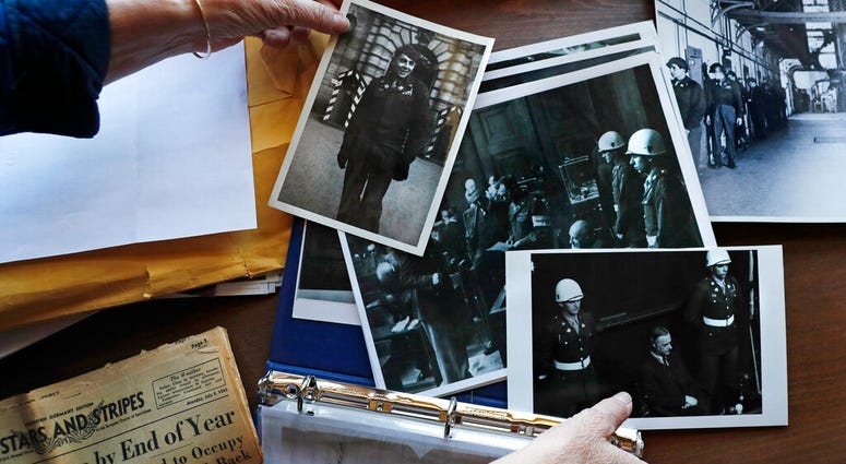 Emily DiPalma Aho looks over photographs and memorabilia of her father, Emilio DiPalma, a World War II veteran