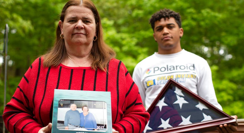 In this Friday, May 22, 2020, photo Florence Hopp, left, holds a photograph of herself and her husband Robert Hopp