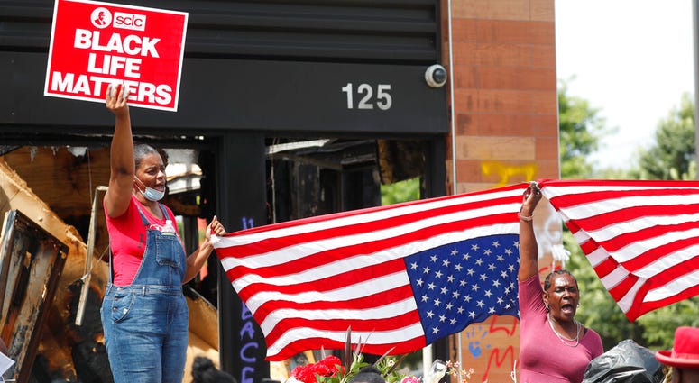 Protesters chant outside a Wendy's restaurant on Tuesday, June 23, 2020, in Atlanta after a funeral for Rayshard Brooks was held