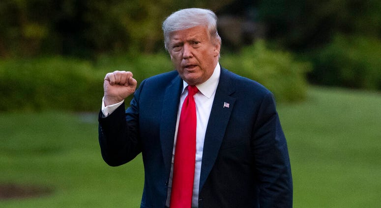 President Donald Trump pumps his fist as he walks on the South Lawn after arriving on Marine One at the White House, Thursday, June 25, 2020, in Washington. Trump is returning from Wisconsin.