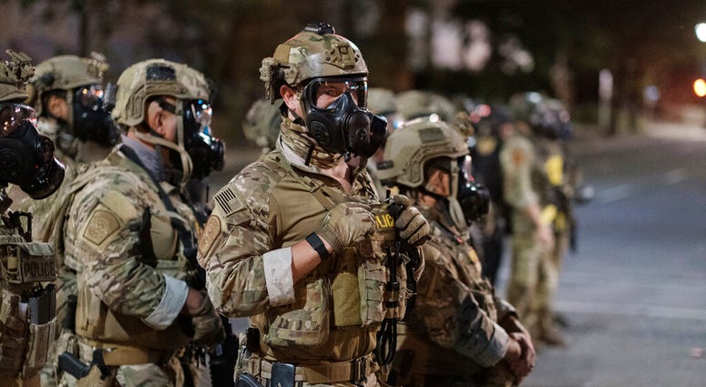 In this photo provided by Doug Brown, agents from different components of the Department of Homeland Security are deployed to protect a federal courthouse in Portland, Ore.