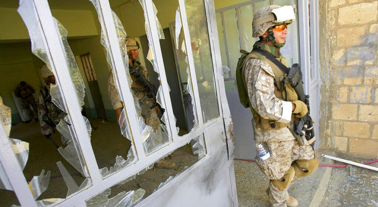 This file photo from Aug. 6, 2005, shows U.S. Marine Staff Sgt. Brian Hamilton of Columbus, Ohio, from Lima Company of the 3rd Battalion, 25th Regiment as he exits after searching a school
