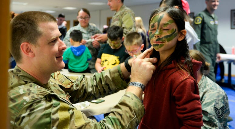A member of the 352nd Special Operations Wing puts on camouflage paint on a child during the second annual Month of the Military Child celebration hosted by the 100th Operations Group at RAF Mildenhall, England, April 24, 2018. During the celebration, chi 352ndSpecialOperationsWing