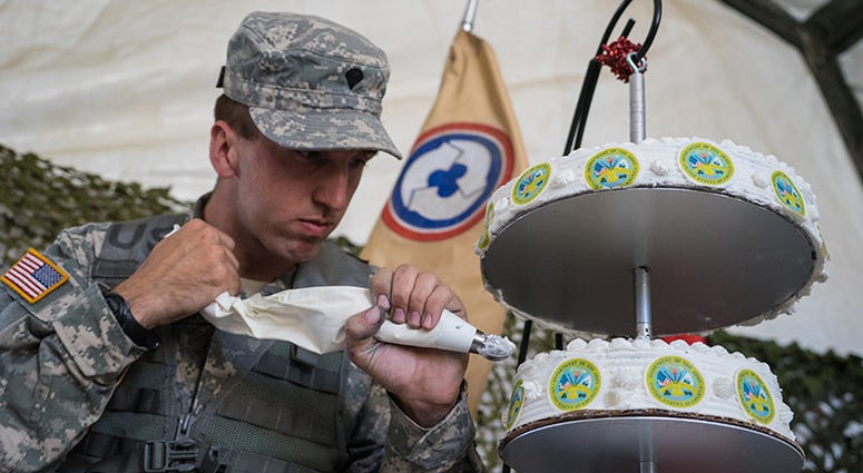 Spc. Thomas Branson, an Army Reserve culinary specialist, 311th Sustainment Command (Expeditionary), decorates an Army birthday cake, Camp Roberts, Calif., June 14, 2016.