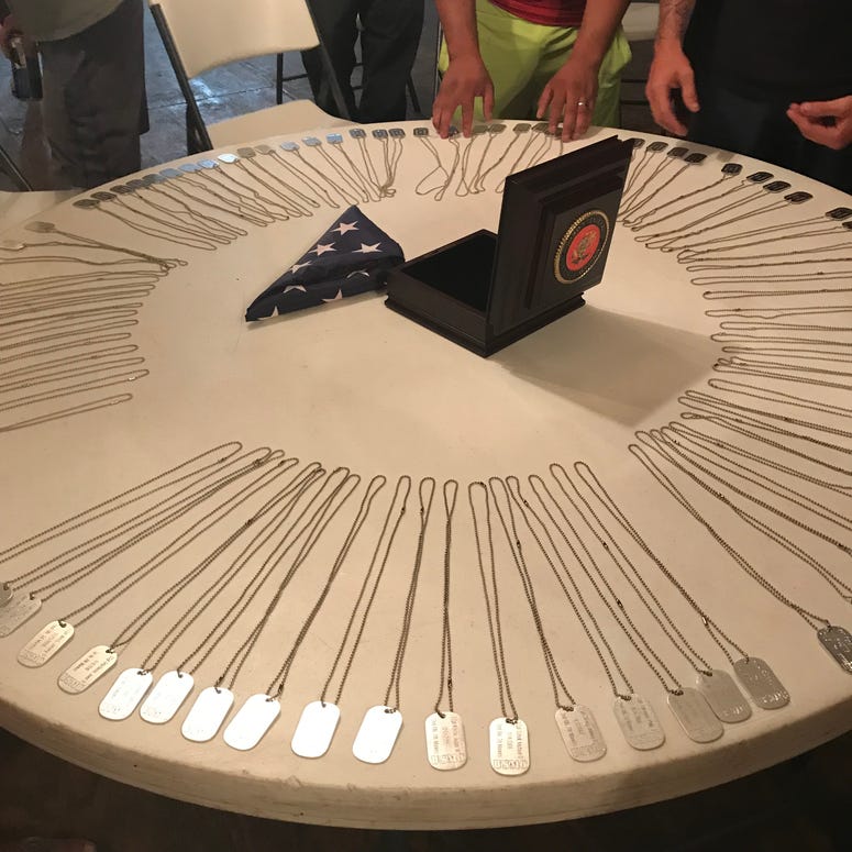 Marines gather around a collection of dog tags of comrades lost in combat or to suicide. Reunion2