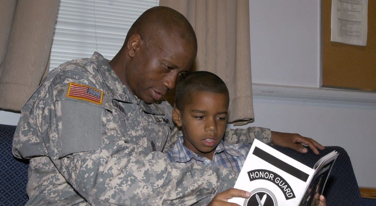 Army 1st Sgt. Steven Colbert takes a moment out of his day to read with his son, Jordan. Colbert is looking forward to transferring his GI Bill benefits to pay for Jordan's college education.