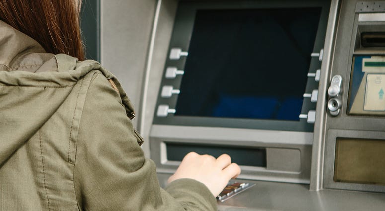 A young woman takes money from an ATM A young woman takes money from an ATM