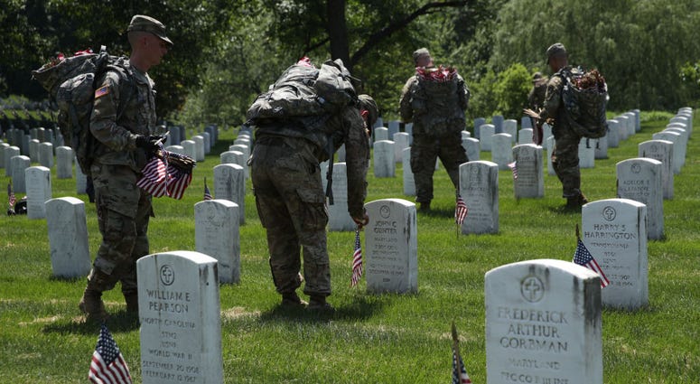 Soldiers with the U.S. Army 3rd Infantry Regiment (The Old Guard) participate in a "Flags In" event May 23, 2019 at Arlington National Cemetery in Arlington, Virginia. ArlingtonCemetery