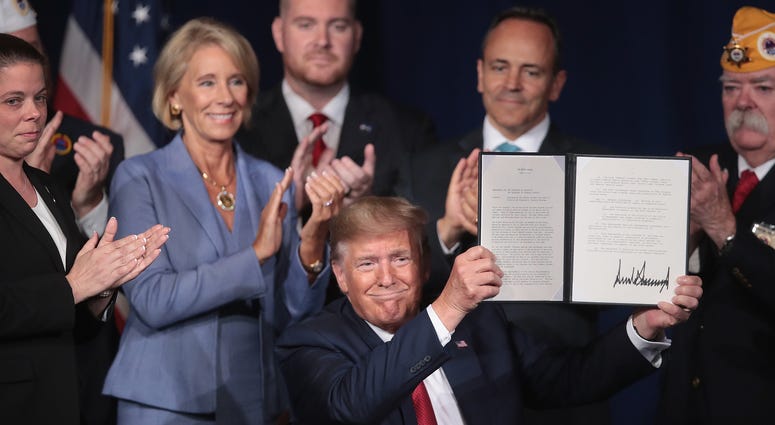 President Donald Trump signs a proclamation that will eliminate student loan debt for qualifying disabled veterans following a speech at the American Veterans (AMVETS) 75th National Convention. President Trump Addresses American Veterans 75th National Convention