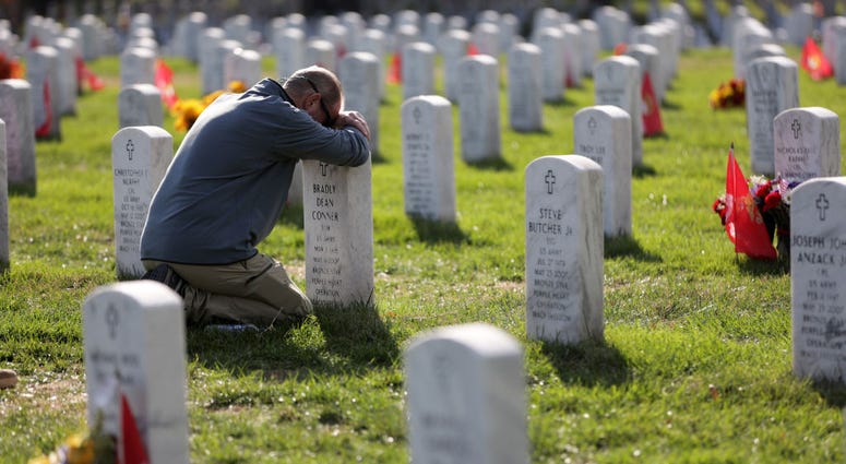 Chris Plank of Maryland holds the headstone of his friend Army Sgm. Bradly Dean Conner, who was killed in Iraq, at Section 60 at Arlington National Cemetery. MemorialDay