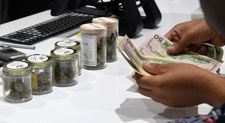 A customer pays for cannabis products at Essence Vegas Cannabis Dispensary. VA denies veteran home loan because of his marijuana industry job.