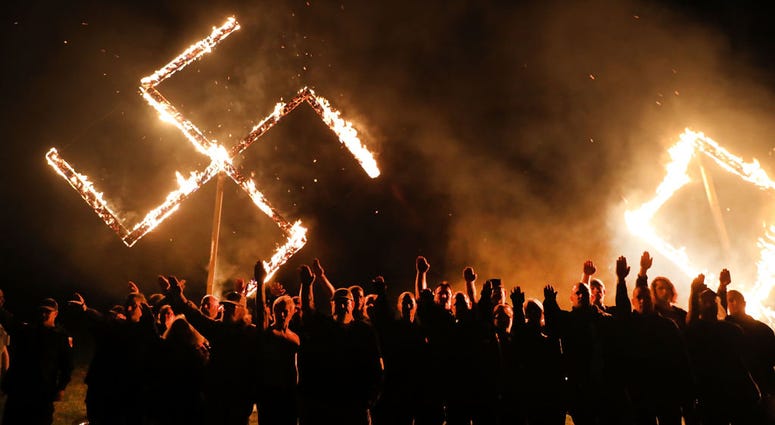 DRAKETOWN, GA - APRIL 21: Members of the National Socialist Movement, one of the largest neo-Nazi groups in the US, hold a swastika burning after a rally on April 21, 2018 in Draketown, Georgia. Community members had opposed the rally in Newnan and came o DRAKETOWN, GA - APRIL 21: Members of the National Socialist Movement, one of the largest neo-Nazi groups in the US, hold a swastika burning after a rally on April 21, 2018 in Draketown, Georgia. Community members had opposed the rally in Newnan and came o