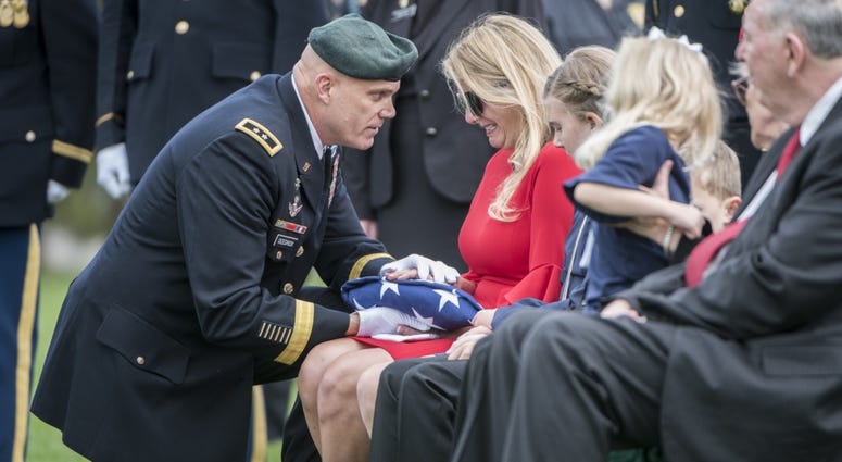 U.S. Army Maj. Gen. Edwin Deedrick, Jr presents the U.S. flag to Tabitha Farmer during the funeral for her husband, U.S. Army Chief Warrant Officer 2 Jonathan Farmer, at Arlington Cemetery April 9, 2019. GoldStarSpouseatFuneral