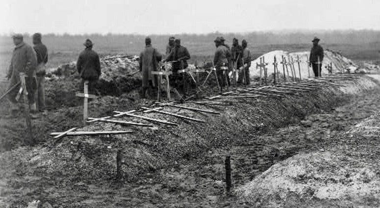 Filling in graves at Fère-en-Tardenois battlefield cemetery, France during World War I.