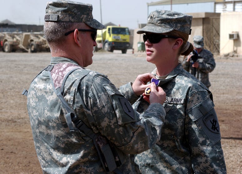 Col. Ricky Gibbs, commander, 4th Brigade Combat Team, 1st Infantry Division, Multi-National Division - Baghdad, places a Purple Heart on the collar of Sgt. Jennifer Hunt, a civil affairs specialist assigned to Company A, 450th Civil Affairs Battalion (Air