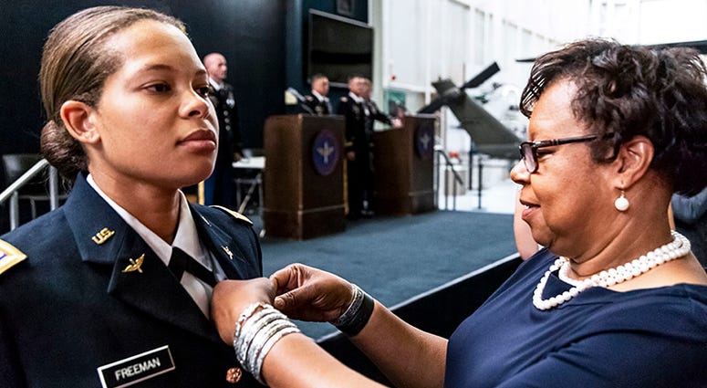 Retired Col. Christine Knighton pins aviator wings on 2nd Lt. Kayla Freeman at Freeman's graduation from the Army Aviation school, June 21, 2018, at Fort Rucker, Alabama.