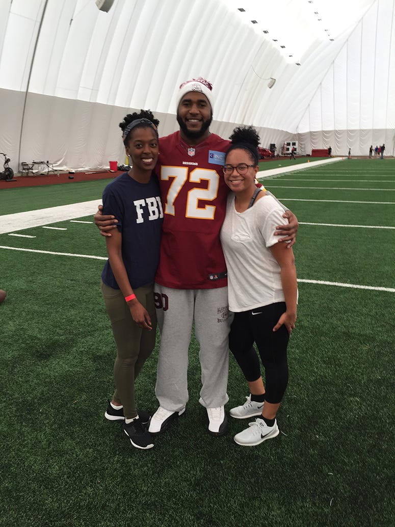 Kaylah pictured with a relative (far left) and Redskins defensive lineman Anthony Lanier II (middle).
