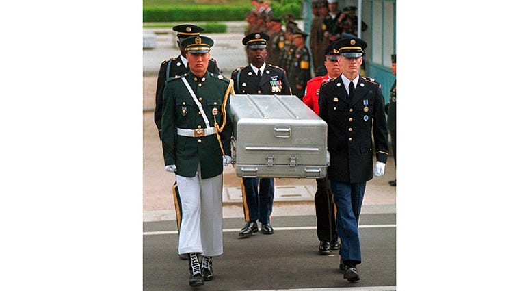 In this May 14, 1999, file photo, U.N. honor guards carry a coffin containing the remains of the American soldiers after it was returned from North Korea at the border village of Panmunjom, South Korea.