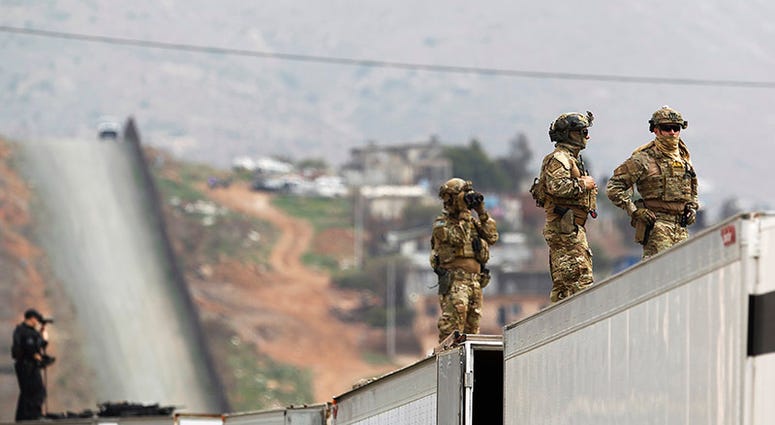 Military Police keep watch near the Mexico border as President Donald Trump takes a tour of the border wall prototypes near the Otay Mesa Port of Entry in San Diego County, Calif., on March 13, 2018.