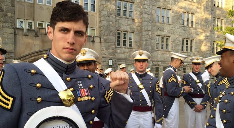 2nd Lt. Spenser Rapone poses with a closed-fist salute and "communism will win" written inside of his cover, while in uniform on the West Point campus.