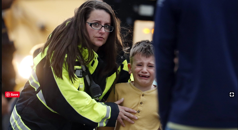 Officials guide students off a bus and into a recreation center where they were reunited with their parents after a shooting at a suburban Denver middle school Tuesday, May 7, 2019, in Highlands Ranch, Colo.