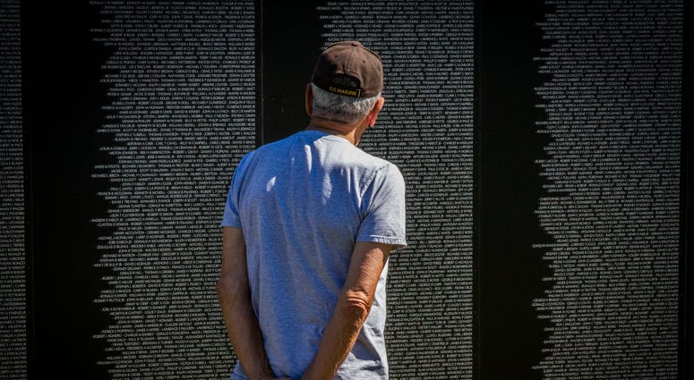 A Marine Corps veteran looks at the names of his friends lost in the Vietnam War on the American Veterans Traveling Tribute memorial wall, Sept. 17. The AVTT wall was in Boston from Sept. 16 through 20 in conjunction with the Congressional Medal of Honor South Boston's Vietnam War Memorial Is Rededicated