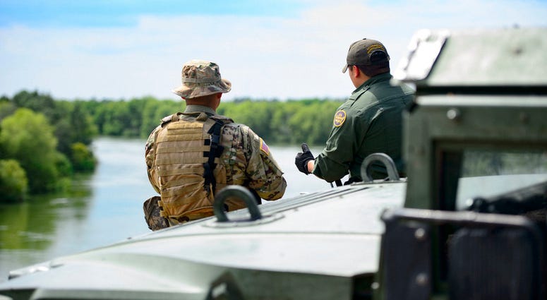 A Texas Guardsmen and a Customs and Border Patrol agent discuss the lay of the land April 10 on the shores of the Rio Grande River in Starr County, Texas as part of the federal call-up to the Texas Mexico border. Soldiers called to duty at the border supp Photo by Sgt. Mark Otte