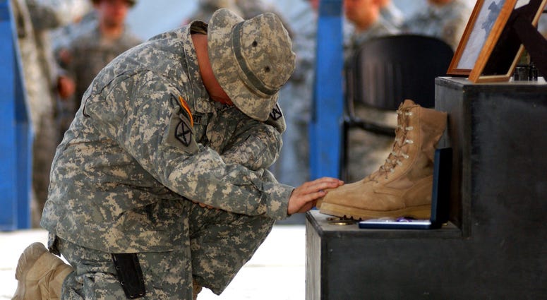 A Soldier pays his respects to Staff Sgt. Travis Atkins, who was killed June 1 by a suicide bomber near Sadr Al-Yusufiyah, Iraq, at a memorial ceremony held June 7 at Camp Striker. Atkins was on a patrol with his unit, Company D, 2nd Battalion, 14th Infan Staff Sgt. Travis Atkins will recieve the Medal of Honor